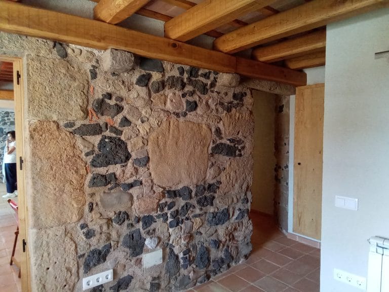 Sorrejats interiors en paret de pedra combinada amb bigues de fusta a Girona
