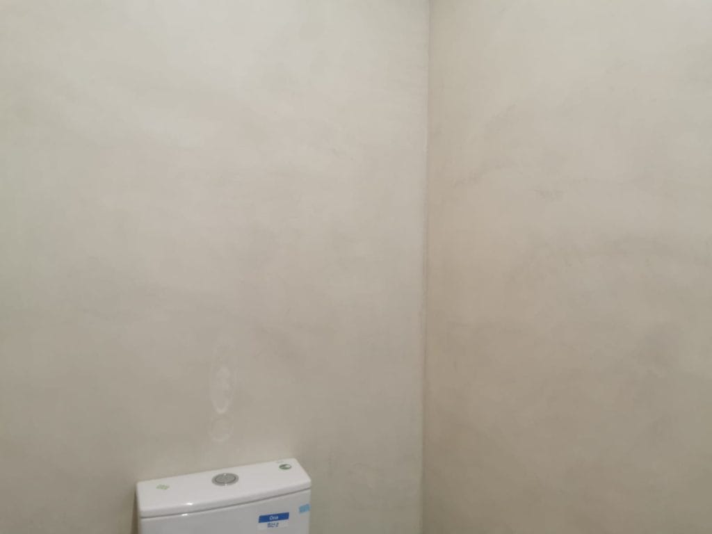 Zona del bany amb revestiment de microciment suau i tons neutres a Girona.