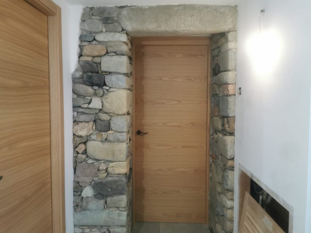 Arc de pedra interior restaurat amb sorrejats a Girona en entrada de vivenda